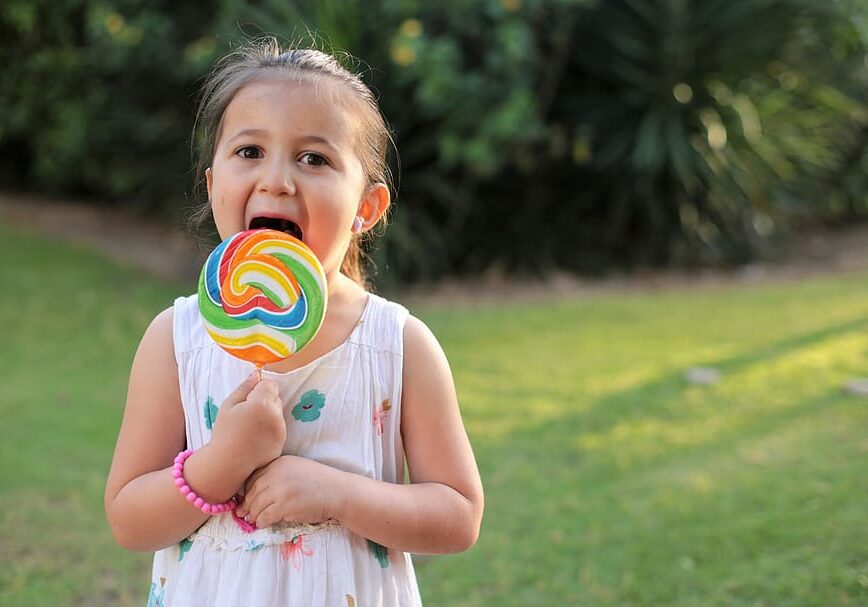Toddler eating multicoloured lollipop. Source: Wallpaper Flare
